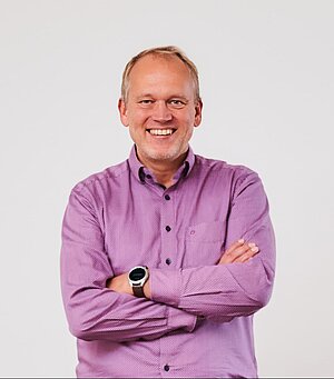 Mark König im Porträt mit rosafarbenem Hemd