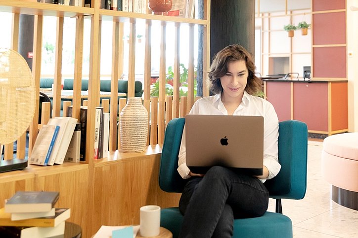 Frau sitzt mit einem Laptop in der Lobby des Aparthotel Adagio Paris Nation, wo das „Office on demand“ mit Wojo bisher genutzt wird. © Aparthotels Adagio