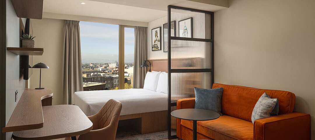 Die Queen Studio Suites des Home2 Suites by Hilton Dublin City Centre warten mit separiertem Ess-, Wohn- und Arbeitsbereich auf. © 2026 Hilton
