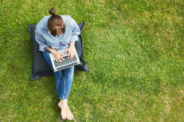 Arbeiten auf der Apartmenthaus-Wiese oder auf im Dachgarten – Büro ist überall in Serviced-Apartment-Betrieben. © stock.adobe.com_Robert Kneschke
