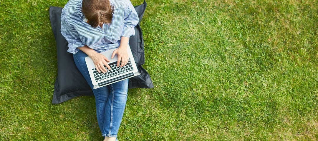 Arbeiten auf der Apartmenthaus-Wiese oder auf im Dachgarten – Büro ist überall in Serviced-Apartment-Betrieben. © stock.adobe.com_Robert Kneschke